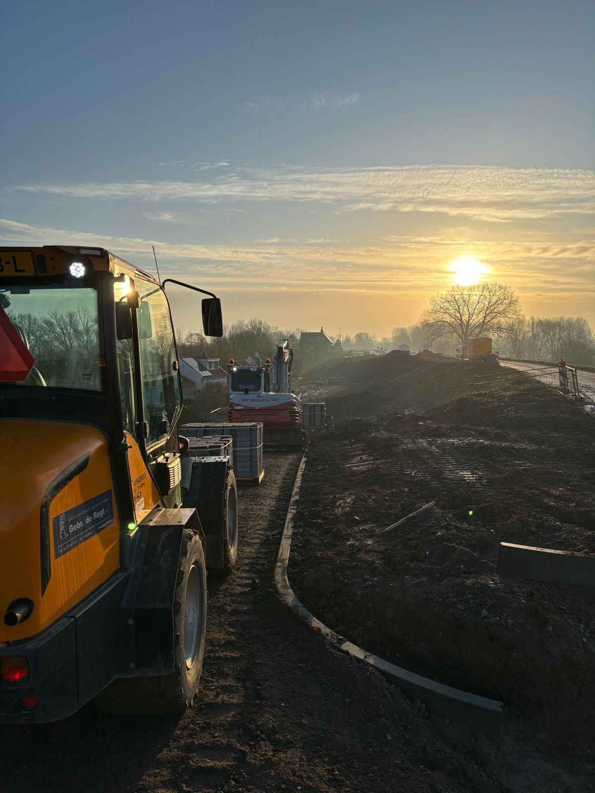 Graafmachine tijdens grondwerk aan de dijk