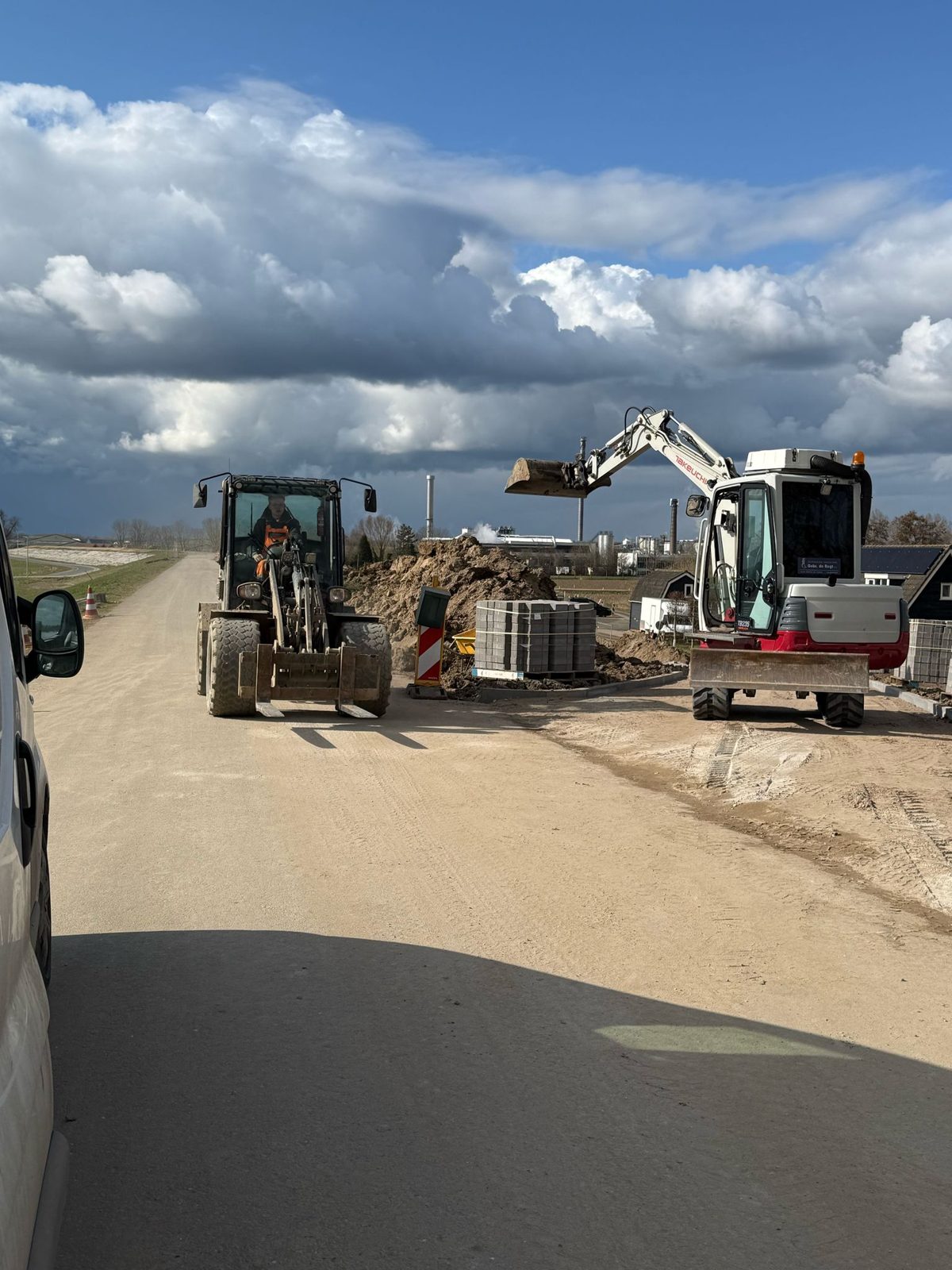 Straatmachines aan het werk bij zonsondergang