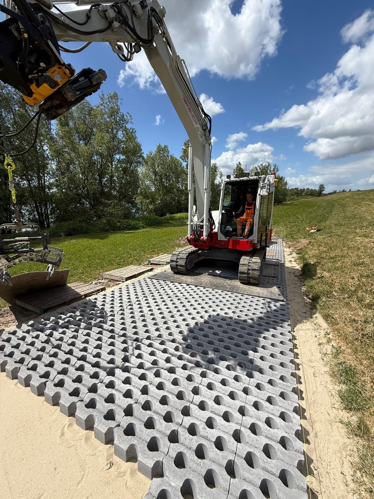 Grondwerk met grasbetontegels op de voorgrond