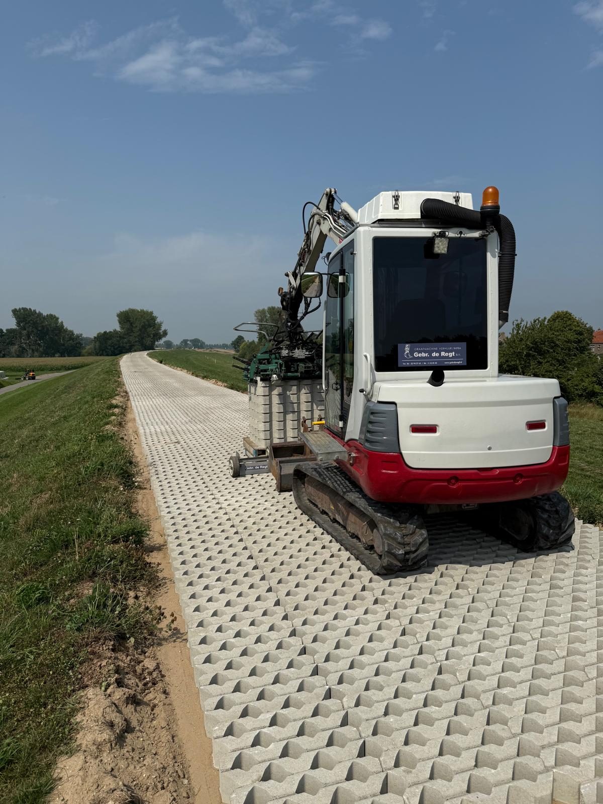 Graafmachine op de dijk met zicht op de rivier bij Gorinchem