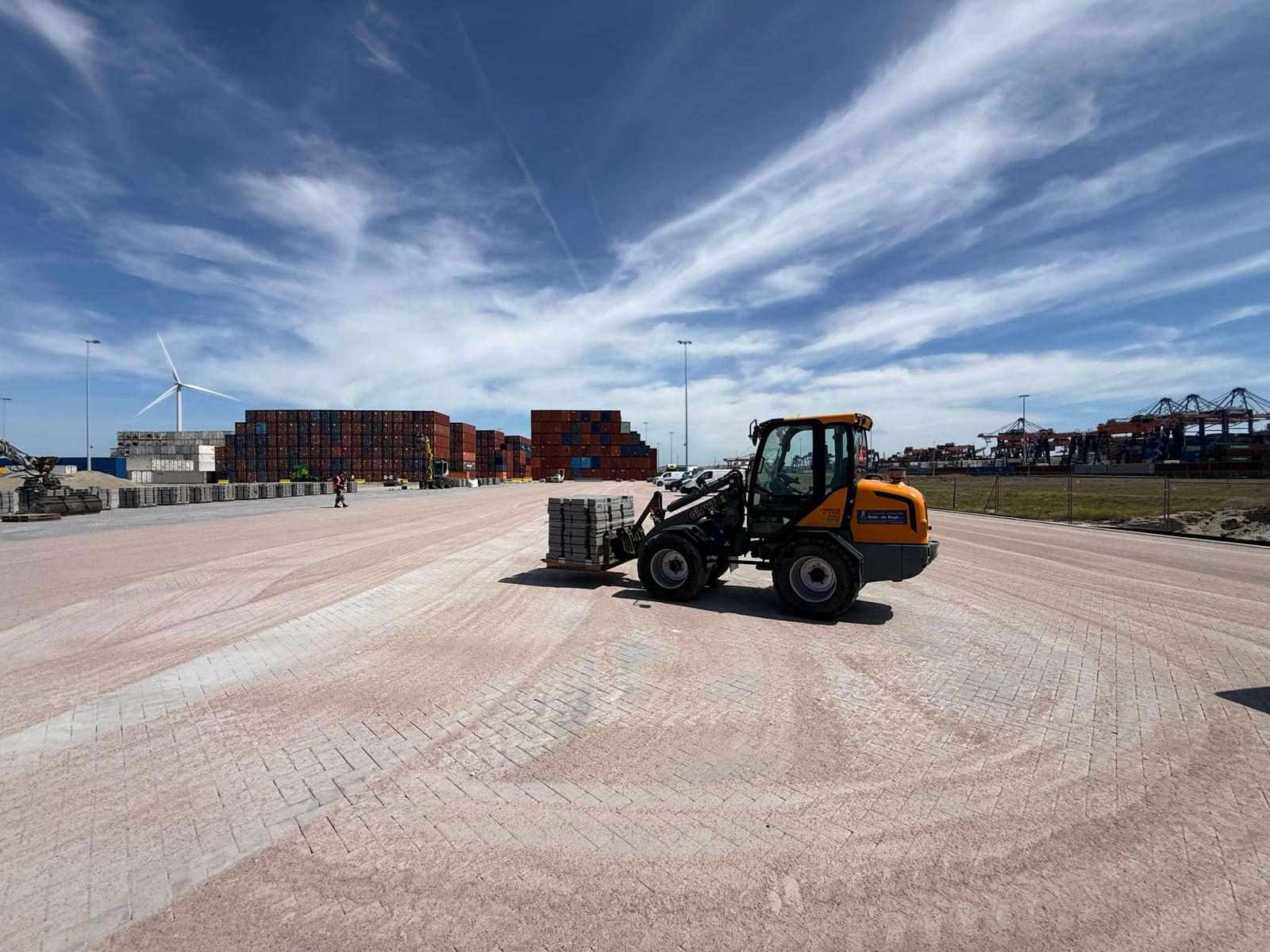 Materieel op de terminal met havenkranen op de achtergrond