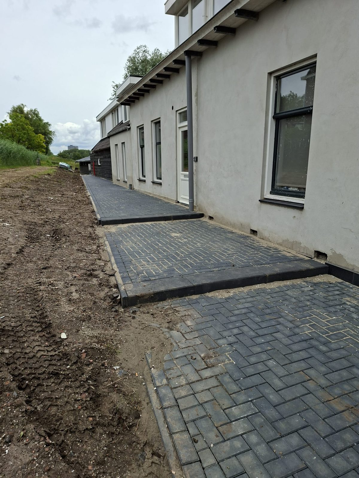Nieuw straatwerk langs de gevel van een woning in Rotterdam